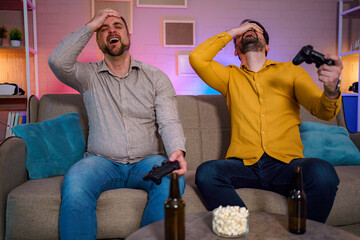 Friends enjoying gaming night with excitement and snacks at home