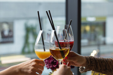 Friends celebrate their gathering while raising colorful non-alcoholic healthy juice drinks. The atmosphere is lively, filled with joy and engaging conversations.