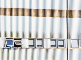 Windows of an industrial building reflect urban architecture in Falkenberg, Sweden