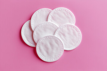6 white facial swabs on a pink background