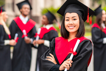 Happy young asian lady student having graduation party, wearing graduation costume and holding...
