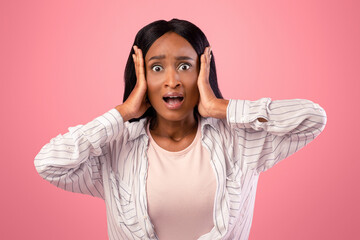 No way. Shocked black woman grasping her head in disbelief over pink studio background. Amazed...