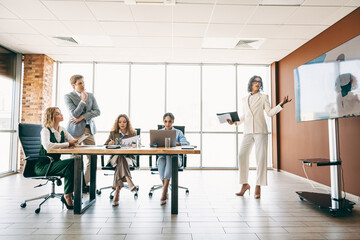 Professional team collaborating in modern office during a meeting with focus on teamwork and...