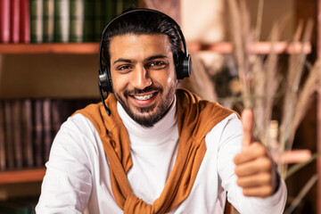 I Like Distance Learning. Cheerful Indian Student Guy Gesturing Thumbs Up Smiling To Camera Sitting...