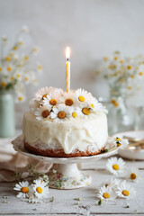A beautiful birthday cake with daisies on top, against a white background