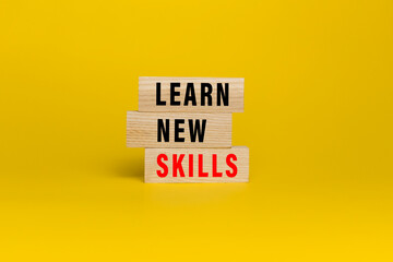 learn new skills words text on wooden blocks isolated on yellow background