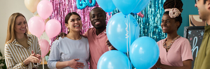 Group of young adult multiethnic friends celebrating gender reveal party, smiling and interacting