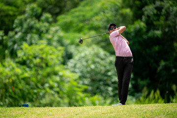 A man is swinging a golf club