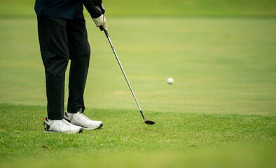 A man is playing golf and has just hit a ball