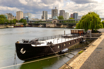 Fototapeta premium Houseboat docked on Seine River near Bir-Hakeim Bridge in Paris