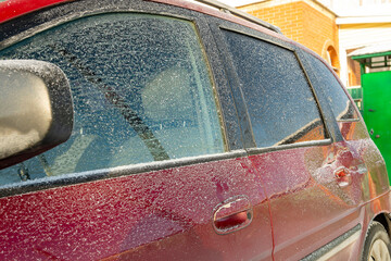 Red car door dented after accident, car hit. Impact damage. Damaged rear door of car, dent after road collision