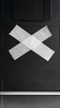 Obsolete black floppy disk sealed shut with white tape, a vintage reminder of outdated technology and data storage failure.