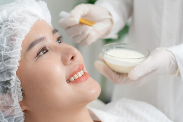 Beautiful woman receive spa and treatment skin of face. face of a healthy woman apply cream....