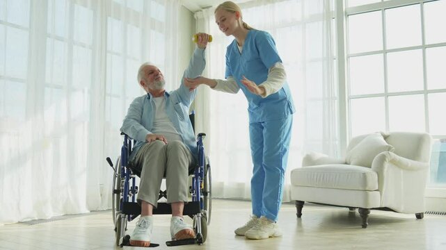 Support rehabilitation healthcare. Nurse helps old man patient in wheelchair picking up dumbbells. Paralyzed man in chair for people with disability doing sports exercise with nurse. Medical caregiver