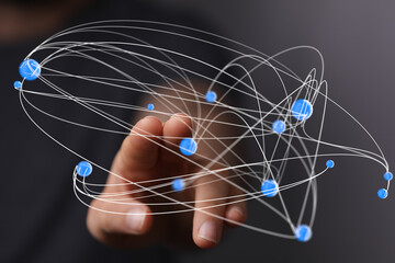 Abstract image depicting a hand interacting with a complex network of interconnected nodes,...