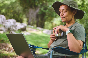 Woman Enjoying Nature While Using Laptop and Drinking Coffee Outdoors