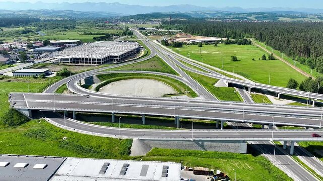 End of new Zakopianaka highway in Nowy Targ, Poland. Interchange with old road from Krakow to Zakopane. State in 2025. Continuation planned. Far foggy view of Tatra mountains. Aerial 4K video