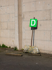 Industrial building signage in Sweden displays letter D against a gray wall in an urban setting