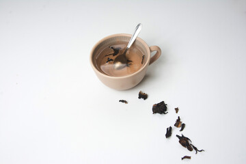 Cup of  tea with dry tea leaves on a white background