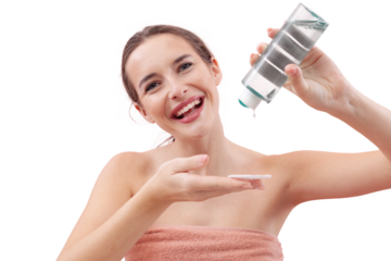 Smiling young woman pouring micellar water onto a cotton pad before cleansing her face. Skincare routine, makeup removal, healthy skin. Isolated on white background, beauty and hygiene concept.