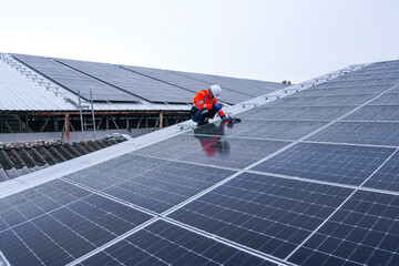 Engineers install solar panels on a wet rooftop during cloudy weather