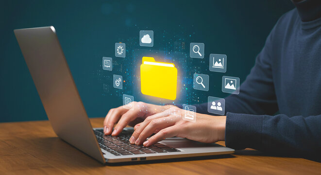 Person typing on a laptop with a digital folder and icon overlay on a dark background on a wood table