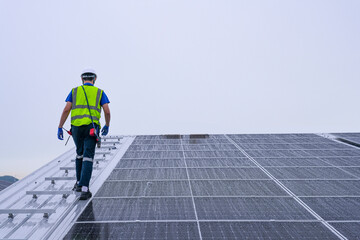 Engineers install solar panels on a wet rooftop during cloudy weather