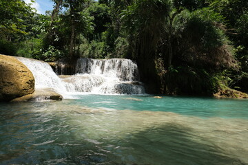 A waterfall is flowing into a pool of water