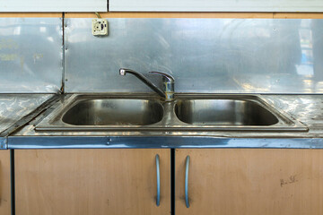 Dirty empty double sink inside restaurant kitchen interior