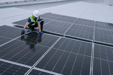 Engineers install solar panels on a wet rooftop during cloudy weather