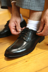 Man tying shoelaces. Stylish men's shoes.
