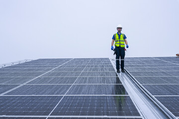 Engineers install solar panels on a wet rooftop during cloudy weather