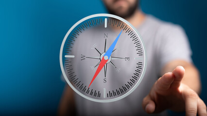 Stock photo of a man interacting with a digital compass, symbolizing guidance and direction.