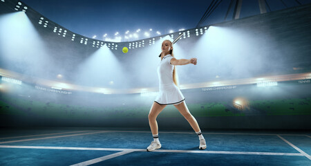 Woman tennis player playing tennis on professional tennis stadium in night.