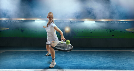 Woman tennis player playing tennis on professional tennis stadium in night.