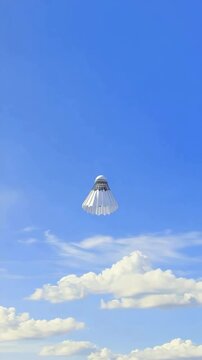 A white badminton shuttlecock is flying in the air. The shuttlecock is white and has a black stripe