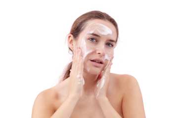 Close up of young woman cleansing her face with foaming cleanser, hands covered in foam while applying it to her skin. Skincare routine for clean, healthy face. Isolated on white background, acne care