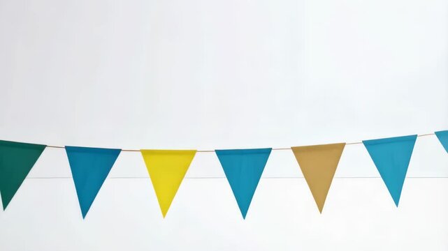 Colorful triangular paper pennant banner with gold patterns strung along a plain white wall, creating cheerful decorations for party or celebration background.