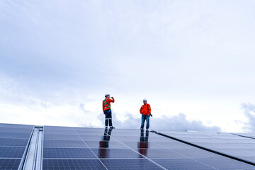 Obraz premium Engineer in safety gear standing on large solar panel rooftop