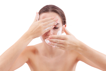 Close up of young woman cleansing her face with foaming cleanser, hands covered in foam while applying it to her skin. Skincare routine for clean, healthy face. Isolated on white background, acne care