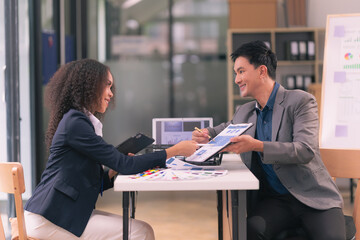 Two businessmen looking at computer screen with many graphs and charts and tablet for statistics, financial reports and planning revenue, profit or sales in office.