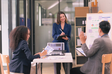 Group of business people discussing charts and graphs showing results of teamwork, analyzing financial data at desk in modern office about business strategy.