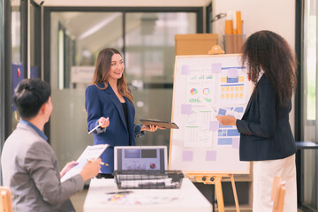 Group of business people discussing charts and graphs showing results of teamwork, analyzing financial data at desk in modern office about business strategy.