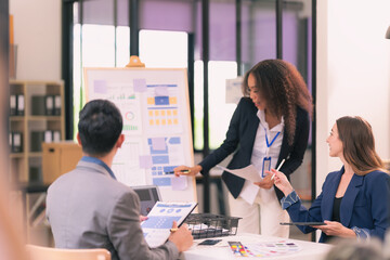 Group of business people discussing charts and graphs showing results of teamwork, analyzing financial data at desk in modern office about business strategy.