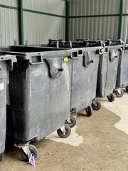 A Row of Industrial Waste Bins Equipped with Wheels for Easy Transportation and Use. A set of...