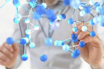 Close-up of a scientist manipulating a 3D molecular model, representing research and innovation.