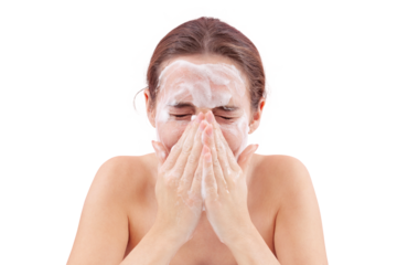 Close up of a young woman washing her face with hands covered in foam touching her skin. Deep cleansing skincare routine for clean, healthy skin. Isolated on white background, acne care concept