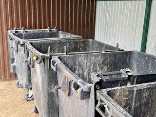 A Row of Industrial Waste Bins Equipped with Wheels for Easy Transportation and Use. A set of...