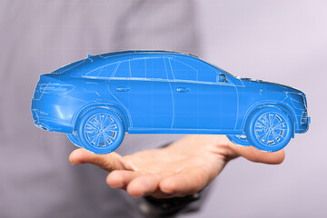 High-quality stock photo of a digital car model hovering above a hand. Perfect for automotive...