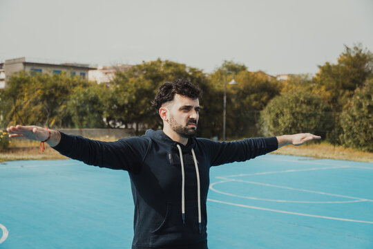 Basketball Player Warms Up His Arms for the Outdoor Match